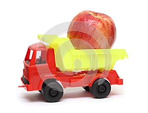 Food transportation concept - toy lorry with apple