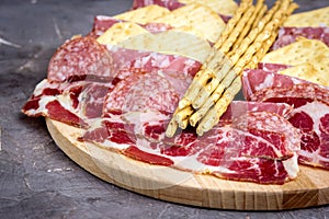 Food Tray With Delicious Salami Pieces of Sliced Ham and Crackers and Bread Sticks Meat Plate