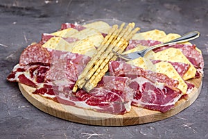 Food Tray With Delicious Salami Pieces of Sliced Ham and Crackers and Bread Sticks Meat Plate