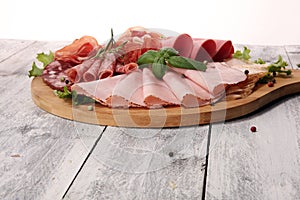 Food tray with delicious salami, pieces of sliced ham, sausage a