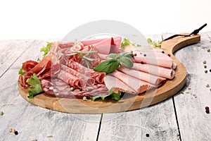 Food tray with delicious salami, pieces of sliced ham, sausage a