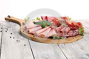 Food tray with delicious salami, pieces of sliced ham, sausage a