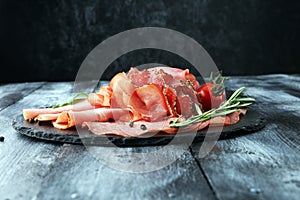 Food tray with delicious salami, pieces of sliced ham, sausage,