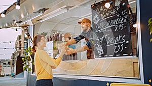 Food Truck Employee Hands Out a Freshly Made Gourmet Burger to a Happy Young Female. Young Man in