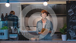 Food Truck Female Employee Hold Tasty Burger, Smiles and Looks at the Camera. Street Food Truck Se photo