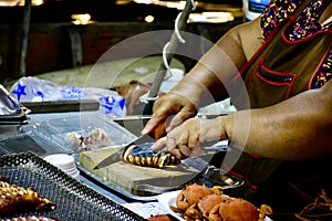 Food vendor cuts grilled squid