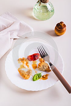 Food waste and cutlery on a dirty plate on the table vertical view