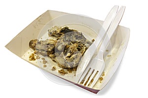 Food waste on paper plates with plastic knives and forks isolate