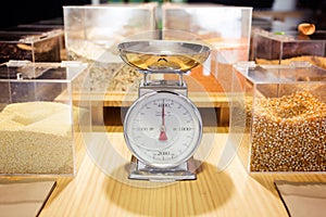 Food weighing machine and different types of condiments in bulk in an organic store.