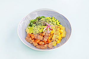 Foodporn poke bowl with edamame and wakame, marinated Norwegian salmon, chopped Asian mango, ripe avocado fillets,
