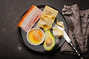 Foods for keto diet on black plate on dark background