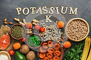 Foods rich in potassium, salmon, legumes, vegetables, fruits on a dark background. Healthy food concept,avitaminosis prevention. photo