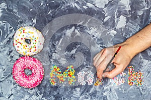 Foodstylist lays out the composition to the women`s day of donuts and pastry sprinkles