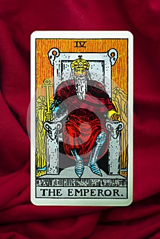 THE FOOL major tarot card of Rider Waite deck on red fabric background