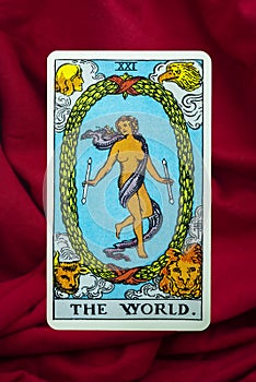 THE FOOL major tarot card of Rider Waite deck on red fabric background