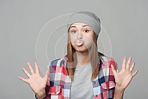 Fooling teen girl blowing bubblegum showing palms