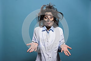 Foolish laughable crazy chemist with messy hair and dirty face does not know why explosion occured during chemical photo