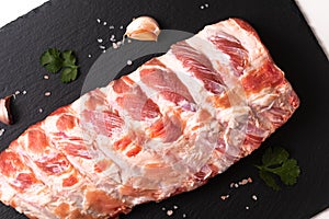 Foos concept organic raw pork ribs on black slate board with copy space