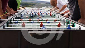 Foosball fanatics. Cropped shot of a group of people playing foosball.