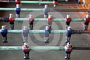 Foosball. Soccer hall game. Traditional game. Soccer game. Table with soccer players. Old wooden foosball. Football players. Dolls