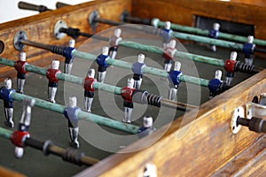 Foosball. Soccer hall game. Traditional game. Soccer game. Table with soccer players. Old wooden foosball. Football players. Dolls