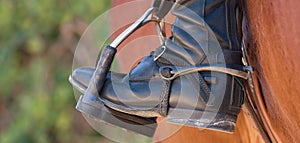 Foot of the athlete in a stirrup astride a horse, the foot of the rider