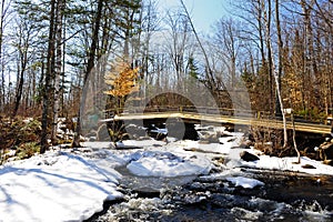 A foot bridge over a snow covered brook