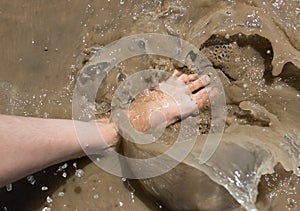 Foot in dirty water with splashes