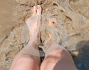 Foot in dirty water with splashes