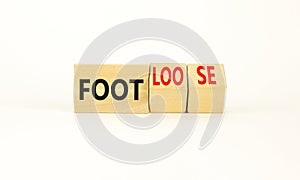 Foot or footloose symbol. Businessman turns wooden cubes and changes word Foot bad to Footloose. Beautiful white table white