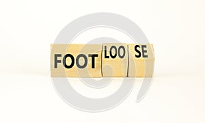 Foot or footloose symbol. Businessman turns wooden cubes and changes word Foot bad to Footloose. Beautiful white table white