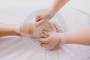 Foot massage close-up. Spa salon self-care relax. Kneading the feet.