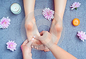 Foot massage at the massage parlor. Female hands massaging the woman`s feet.