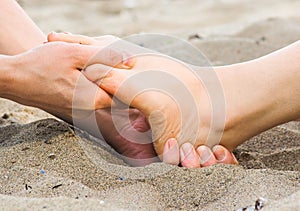 Foot massage in sand, male and female caucasian