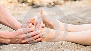 Foot massage in sand, male and female caucasian