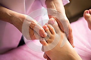 Foot massage in spa salon, closeup,Young woman having feet massage in beauty salon,female hands doing foot massage,Massage of hum