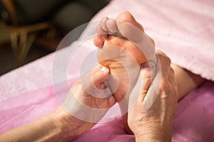 Foot massage in spa salon, closeup,Young woman having feet massage in beauty salon,female hands doing foot massage,Massage of hum