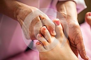 Foot massage in spa salon, closeup,Young woman having feet massage in beauty salon,female hands doing foot massage,Massage of hum