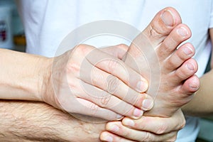 Foot Pain Leg of man sitting on white background and holding he feet and stretch the muscles i .Health care and spa concept