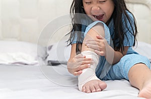 Foot pain. Little kid with broken leg on bed,
