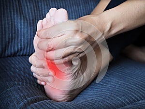 Foot pain, sore feet of young asian woman and use hand to massage feet and soles to relieve pain