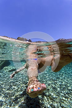 Foot with painted nails underwater