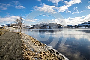 A foot path around scenic Edlandsvatnet lake and mountain landscape in winter near Algard town