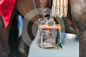 The foot of a rider on the stirrup of a horse