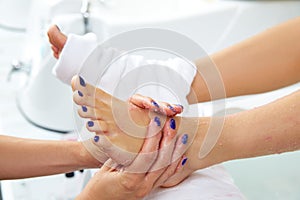 Foot scrub pedicure woman leg in nail salon photo