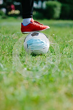 Foot and shoe with soccer football with face mask for sports during covid-19 pandemic