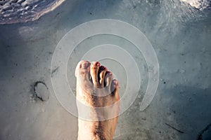 Foot in the small waterpool with thermal water