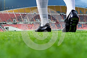 Foot of soccer player or football player walk on green grass