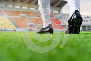 Foot of soccer playerwalk on green grass