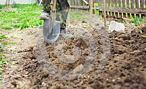 Foot with spade in dirt, farmer working